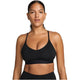 En kvinde med mørkt hår, der er trukket tilbage, bærer Nike Padded Adjustable Sports Bra, Dame, Black/Black med tynde stropper og Dri-FIT-teknologi. Hun ser direkte ind i kameraet mod en almindelig hvid baggrund.