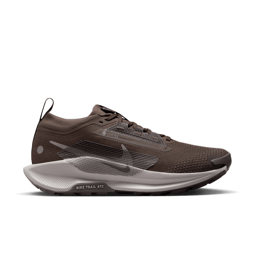Nike Pegasus Trail 5 Gore-Tex Dame i Ironstone/College Grey-Velvet Brown har en overdel i mesh, sorte og grå detaljer, hvid "Nike Trail ATC"-mellemsål og trækflig i hælen. Denne vandtætte løbesko er perfekt som trailsko dame. Vist på en hvid baggrund.