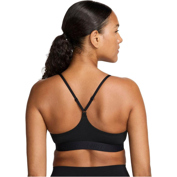 En kvinde med mørkt hår i en hestehale ses bagfra iført Nike Padded Adjustable Sports Bra, Dame, Black/Black. Sports-bh'en har tynde stropper og Nike-logoet på elastikken mod en hvid baggrund.