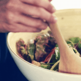 En person, der blander en salat.
