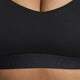 Nærbillede af en kvinde i Nike Padded Adjustable Sports Bra, Dame, Black/Black. Det synlige Nike-logo og Dri-FIT-teknologien giver komfort, støtte og stil - ideelt til træning.