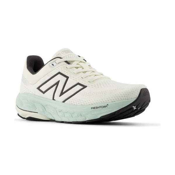 New Balance FreshFoam 860v14 Dame i Sea Salt har en cremefarvet overdel, sort N-logo, lysegrøn FreshFoam-mellemsål, sort ydersål og gråt inderfor, der vises i en vinkel mod en hvid baggrund.