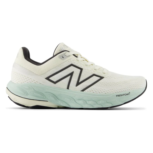 New Balance FreshFoam 860v14, Dame, Sea Salt er en hvid atletisk løbesko med sorte detaljer og stort N-logo. Den har et lysegrønt FreshFoam-mellemsål og åndbart mesh, som giver stødabsorberende komfort og optimal ydeevne.