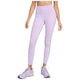 En kvinde står model til Nike One High Waist 7/8 Tight-leggings i lilla sammen med matchende lyslilla sportssko. Overkroppen er delvist synlig, armene er afslappede i siderne på en almindelig hvid baggrund. Mærke: Nike.