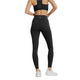 En person iført New Balance Sleek Pocket High Rise Tights, Dame, Black og en sort sports-bh står med ryggen til og viser bagsiden af tøjet. De har også hvide sportssko på mod en almindelig hvid baggrund.