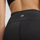 Nærbillede af en person i New Balance Sleek Pocket High Rise Tights, Dame, Black med logo på linningen, stylet med en sort sports-bh.