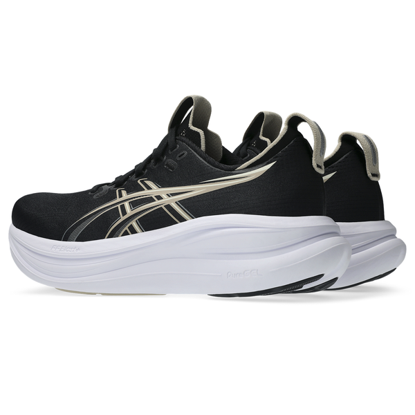 Et par Asics Gel-Nimbus 28 løbesko til kvinder i farvekombinationen Sort/Feather Grey med cremefarvede detaljer og tykke hvide såler er udstillet i en vinkel, der fremhæver både side- og bagfra-udsigten. Disse sko er udviklet med henblik på maksimal stødabsorbering og sikrer, at hvert skridt på din løbetur føles støttet og dæmpet for optimal komfort.