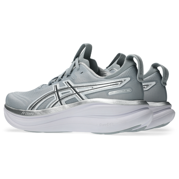 Et par Asics Gel-Nimbus 28 dame løbesko i Piedmont Grey/Pure Silver "Atc" med hvide tykke såler, vist i en vinkel bagfra og fra siden, viser logoet og lagdelt stødabsorbering for ekstra komfort.