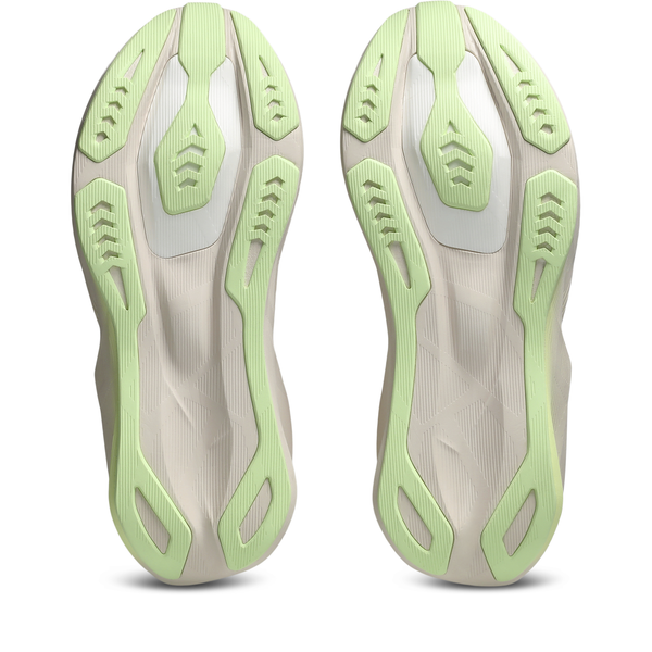 Et par ASICS Novablast 6 Dame-løbeskosåler i farven Rose Dust/Illuminate Yellow, set nedenfra med en beige bund, lysegrønt gummisålmønster og kantede riller, der sikrer godt greb – perfekte som neutrale løbesko til kvinder.