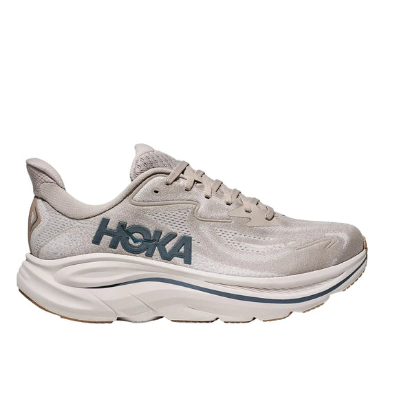 Hoka Clifton 10 til mænd i Putty/Grout har mesh-materiale, beige snørebånd, en tyk hvid sål og blåt Hoka-mærke på siden. Skoen vises på en hvid baggrund.