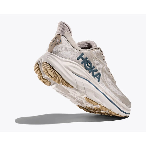 Hoka Clifton 10 til mænd i Putty/Grout er en beige og hvid løbesko med en tyk, støddæmpet sål og en fed sidebranding, der er vist vinklet på en almindelig hvid baggrund.