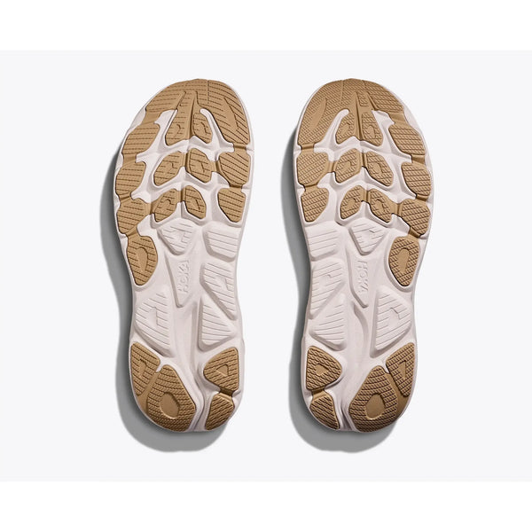 Hoka Clifton 10 Herre i Putty/Grout har atletiske ydersåler med en hvid bund og store solbrune gummisektioner, arrangeret i et struktureret geometrisk mønster for overlegen trækkraft.