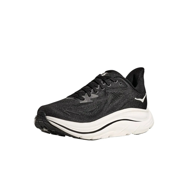 Hoka Clifton 10 Dame i sort/hvid har en struktureret overdel, sorte snørebånd, hvidt logo på siden og en tyk, buet hvid sål. Denne løbesko er vist mod en almindelig hvid baggrund.