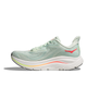 Hoka Clifton 10 Dame i Sea Glass/Neon Flame har en overdel i lysegrønt mesh, tyk hvid sål, neonorange og gule detaljer, synlig støddæmpning, en støttende hæl og et moderne, strømlinet design til mængdetræning.
