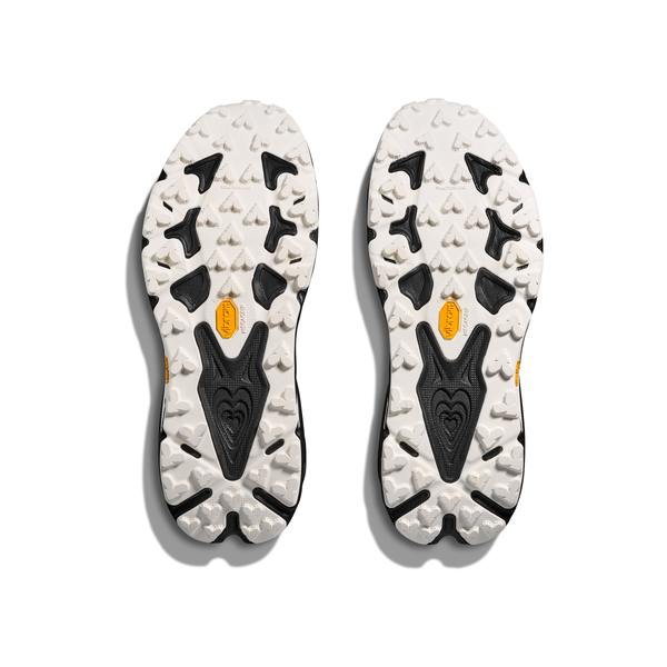 Et par Hoka Speedgoat 7 Herre-såler i sort og hvid med et robust strukturmønster og gule Vibram-logoer, vist ovenfra på en hvid baggrund.