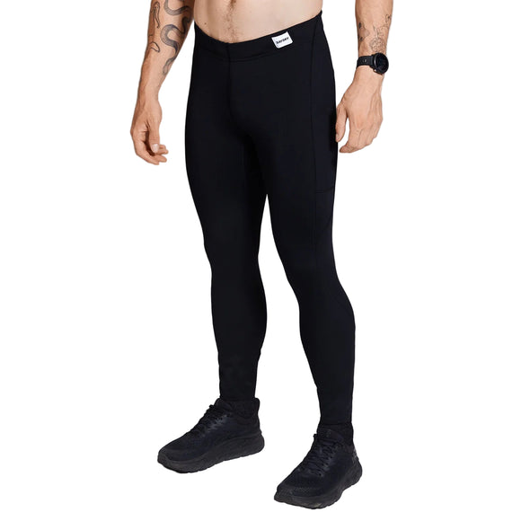 En person iført Motion+ Long Tights, Herre, Black fra Saysky, sammen med sorte sneakers og et sort armbåndsur, står på en hvid baggrund. Kun underkroppen er synlig; overkrop og hoved er ikke vist.