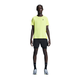 En person ser frem for sig i en lysegul sportstee, On 5" Performance 2/1 Shorts til mænd i sort (åndbart materiale), sorte sokker og grå løbesko. Baggrunden er hvid og ren.