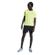 En person iført en gul atletisk t-shirt, On 5" Performance 2/1 Shorts Herre Black, sorte sokker og grå sneakers står med ansigtet lidt til siden mod en hvid baggrund.
