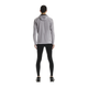 En person står med ryggen til kameraet iført en lysegrå jakke med hætte, On Performance Tights Herre i sort og sorte sneakers på en almindelig hvid baggrund.