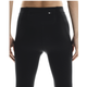 En mand ses fra taljen og ned, med ansigtet vendt væk, iført On Performance Tights, Herre, Black. Hans hænder hviler i siden, mens lyset fremhæver strømpebuksernes tekstur og pasform.