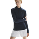 En kvinde står på en hvid baggrund iført On Climate Shirt, Dame, Navy og hvide shorts. Den ene arm er bøjet og holder det modsatte ærme. Det atletiske look har diskret On-branding på bryst og ben.
