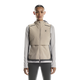 En kvinde kigger fremad, iført On Weather Vest Dame i Desert/Eclipse over en lysegrå langærmet skjorte og sorte leggings, klar til vejrbeskyttelse, der løber mod en almindelig hvid baggrund.