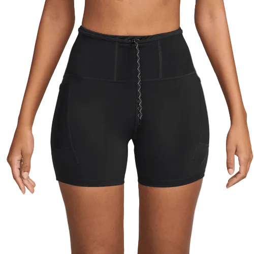En dame viser Nike Dri-FIT High-Waisted 4" Tight Running Shorts i sort/sort med lynlås foran og sidelommer - ideel til dem, der søger komfort og stil, vist fra midt på brystet til midt på låret mod en ensfarvet baggrund.