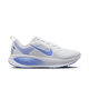 En Nike Vomero 18 løbesko dame i White/Royal Pulse-Football Grey vises i sideprofil med en overdel i mesh, lyseblå swoosh, blå detaljer på sålen og hælen, ZoomX-støddæmpning og hvide snørebånd på en lysegrå baggrund.