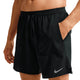 En person er iført Nike Stride 7" Brief-Lined Running Shorts i sort/reflekterende sølv med snøre i taljen og hvidt logo nederst på venstre ben. Den ene hånd er i lommen; overkroppen er synlig, ansigtet er uden for billedet.