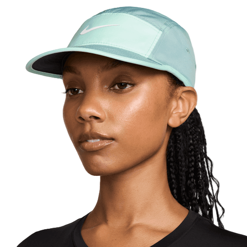 Iført en Nike Fly Unstructured Swoosh Cap i Cannon/Mint Foam/White ser denne person i sort skjorte lidt rigtig ud på en ensfarvet baggrund.