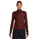En kvinde iført en Nike Dri-FIT 1/2-Zip Trail Running Top i farven Mystic Dates, med halv lynlås, tommelfingerhuller og et lille logo på brystet.