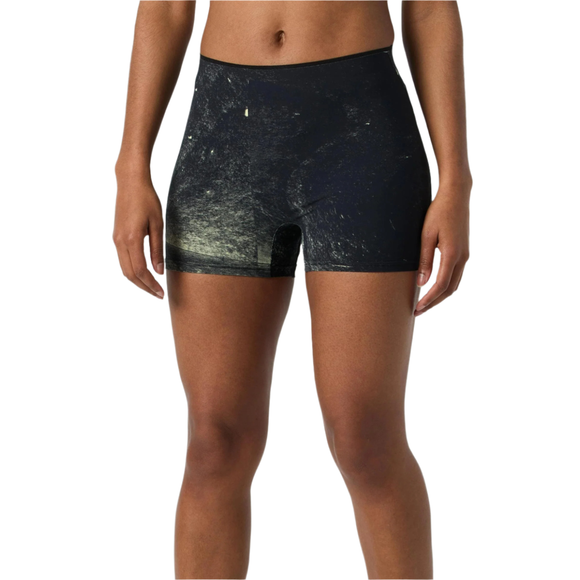 En person står model til On Race Tights Short, Dame i Black/Limelight, med et diskret hvidt og gult stænkmønster på en almindelig hvid baggrund. Kun overkroppen og overbenene er synlige.