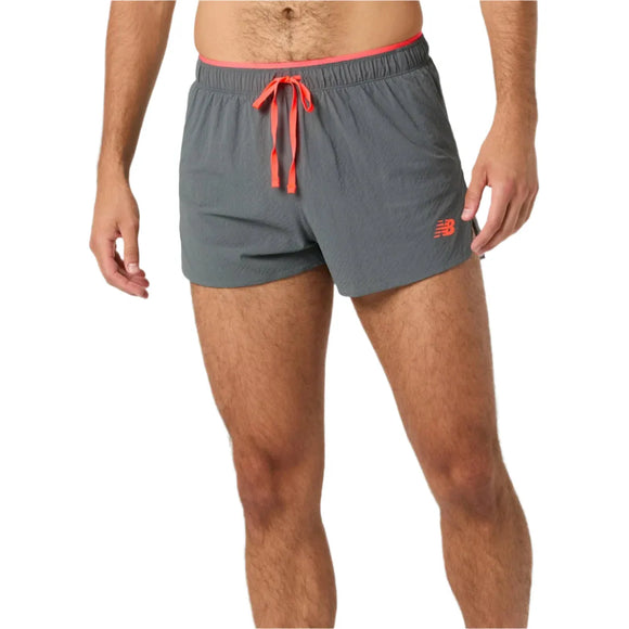 En person er iført grå RC Ultra Light Split Short 3", Herre, Urgent Red fra New Balance med rød løbegang og NB-logo. Inspireret af RC Split Short har disse shorts til midt på låret NB DRY-teknologi for komfort. Personens hoved er ikke synligt.