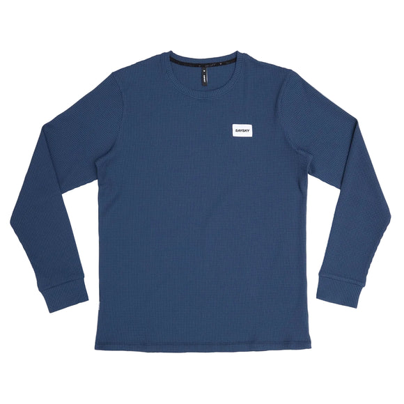 Saysky Motion Waffle Long Sleeve, Herre, Blue - en ribbet skjorte med rund hals og et lille hvidt SATURDAY-mærke på brystet - er teknisk og ideel til løb. Vist lagt fladt på en almindelig hvid baggrund.