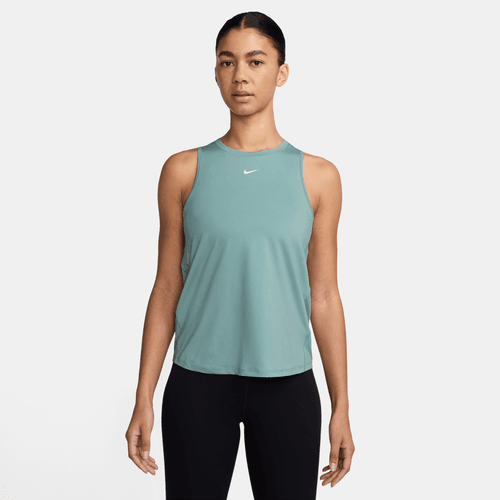 En kvinde står med ansigtet fremad iført en Nike Dri-FIT Classic Tank Top i Cannon/White og sorte leggings på en almindelig hvid baggrund.