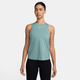 En kvinde står med ansigtet fremad iført en Nike Dri-FIT Classic Tank Top i Cannon/White og sorte leggings på en almindelig hvid baggrund.