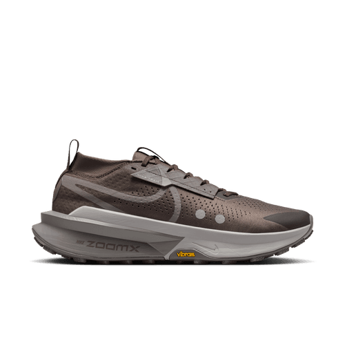 Nike Zegama 2 til mænd i Ironstone/Cave Stone-College Grey har en lav profil, perforeret overdel, tyk sål og synligt "ZOOMX"-branding - ideel til tekniske stier. Vises mod en almindelig hvid baggrund.