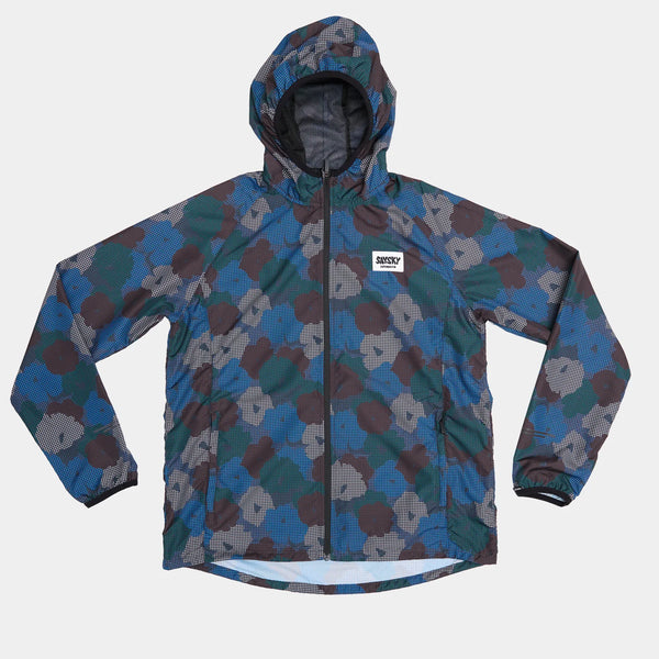 Saysky W Flower Pace Jacket til kvinder (Blue Aop) har hætte med lynlås, lange ærmer, blå-grøn-gråt camouflagemønster, hvidt brystmærke med tekst og er fremstillet af åndbart materiale, vist på en flad lys baggrund.