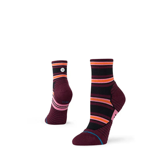 Et par Stance Wayfarer Light Quarter damesokker i fig med pink, orange, sorte og røde vandrette striber, vist på en hvid baggrund.