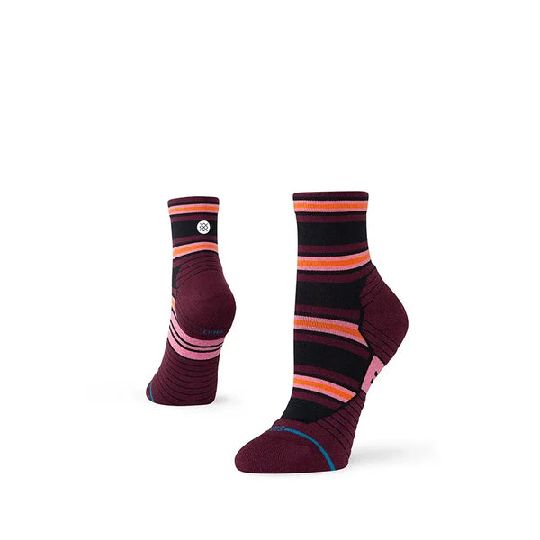 Et par Stance Wayfarer Light Quarter damesokker i fig med pink, orange, sorte og røde vandrette striber, vist på en hvid baggrund.