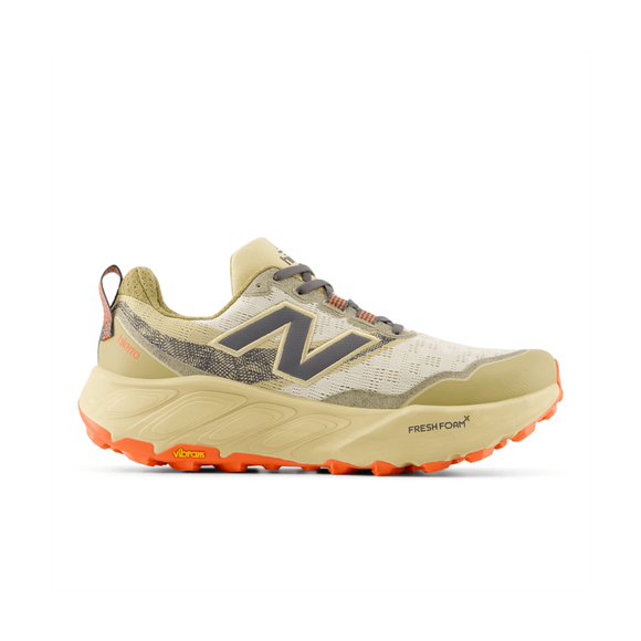 New Balance FreshFoam Hierro v9 til mænd i Linen/Toasted Sesame har en beige og brun overdel, orange Vibram ydersål, gråt logo og Fresh Foam mellemsål til trailløb. Vist i sideprofil på en hvid baggrund.