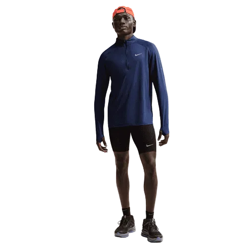 En person iført en midnight navy Nike Stride Half Zip Midlayer Running Top, sorte Nike-shorts, sorte løbesko og en rød kasket står på en almindelig hvid baggrund.