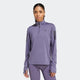 En person iført Adidas Otr B Hzip, Dame, Previo lyslilla quarter zip-top med matchende leggings står med front mod en almindelig hvid baggrund.