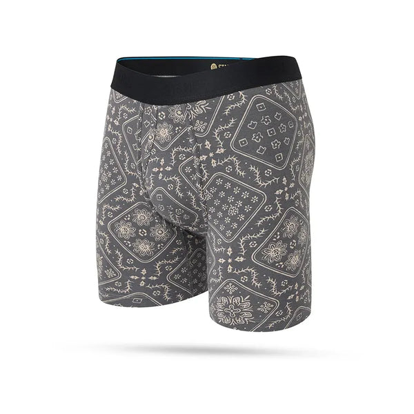 Stance It Is Paisley Wholester herre boxershorts i Stringgrey har en sort linning og et heldækkende gråt og beige Paisley-bandana-mønster, fremstillet i fugttransporterende stof for komfort hele dagen. Vist på en almindelig hvid baggrund.