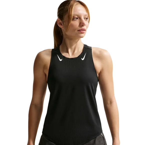 En kvinde iført en Nike AeroSwift Running Singlet, Dame, Black/White med to hvide swoosh-logoer står mod en hvid baggrund og ser til siden.