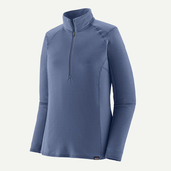 Patagonia Cap TW Zip Neck, Dame in Current Blue er en langærmet top fremstillet af 100 % genbrugspolyester med kvart lynlås foran og opretstående krave, vist på en almindelig hvid baggrund.