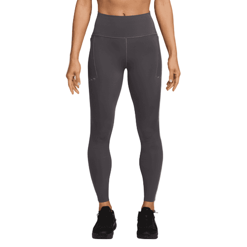 En person står model til Nike Swift High-Waisted 7/8 Running Tights with Pockets, Dame, i Thunder Grey/Reflective Silv sammen med sorte sportssko. De står afslappet på en almindelig hvid baggrund; billedet er beskåret øverst på brystet.