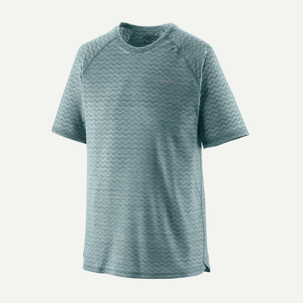 Patagonia M's Ridge Flow Shirt til herrer i Wetland Blue har et diskret zigzagmønster, rund hals og et lille logo-åndbar løbetrøje på brystet på en almindelig hvid baggrund.