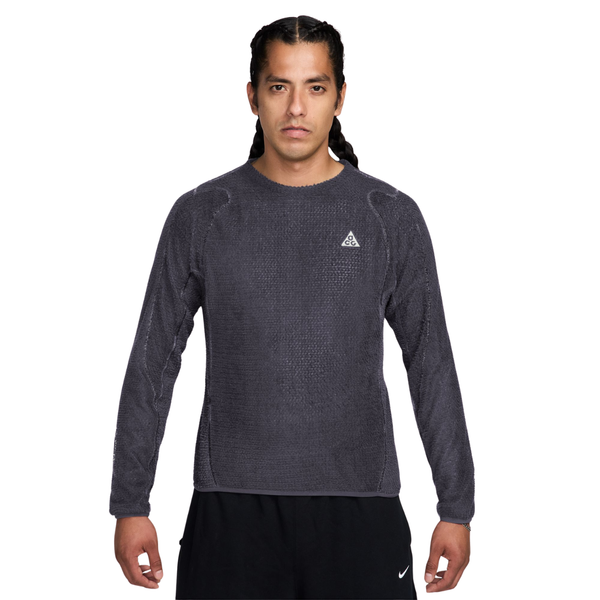 En mand har en antracitgrå, struktureret Nike-trøje med rund hals, Herre, i farvekombinationen Gridiron/Summit White, med et lille trekantet logo på brystet.