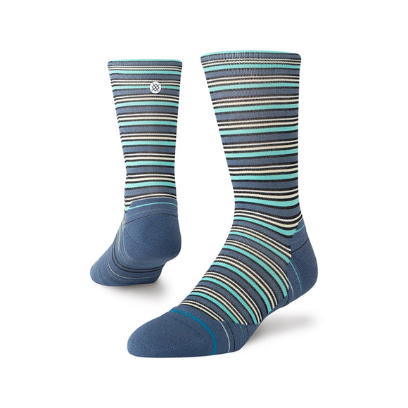 Stance Earnie Light Crew unisex strømper i Seablue har flerfarvede vandrette striber i blå, grøn, hvid og sort. Den ene strømpe står oprejst, mens den anden er vinklet for at vise hælen og sålen - og giver komfort til hver dag.